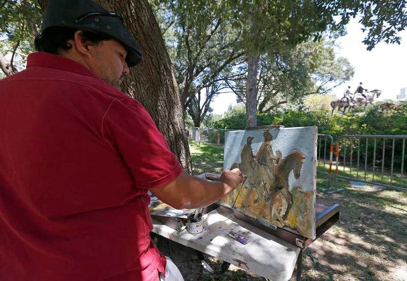 Artist Jerrel Sustaita works on his painting of the Robert E. Lee statue at Robert E. Lee Park in Dallas on Thursday. He said, “I might not be able to do it tomorrow.” (Jae S. Lee/Dallas Morning News)